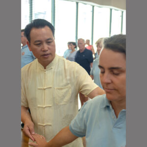 Grossmeister Buyin Zheng korrigiert Schuelerin beim Qigong-Unterricht